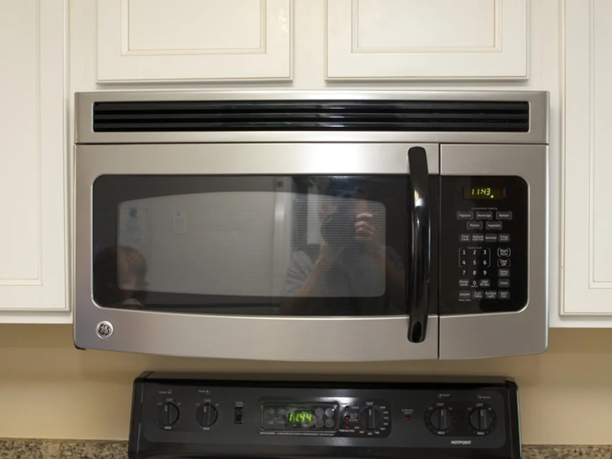 Technician inspecting a microwave oven